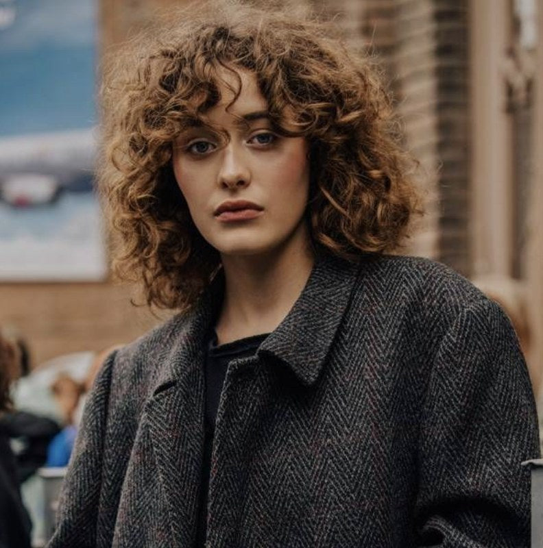 Krullende pony met natuurlijke krul, streetstyle
